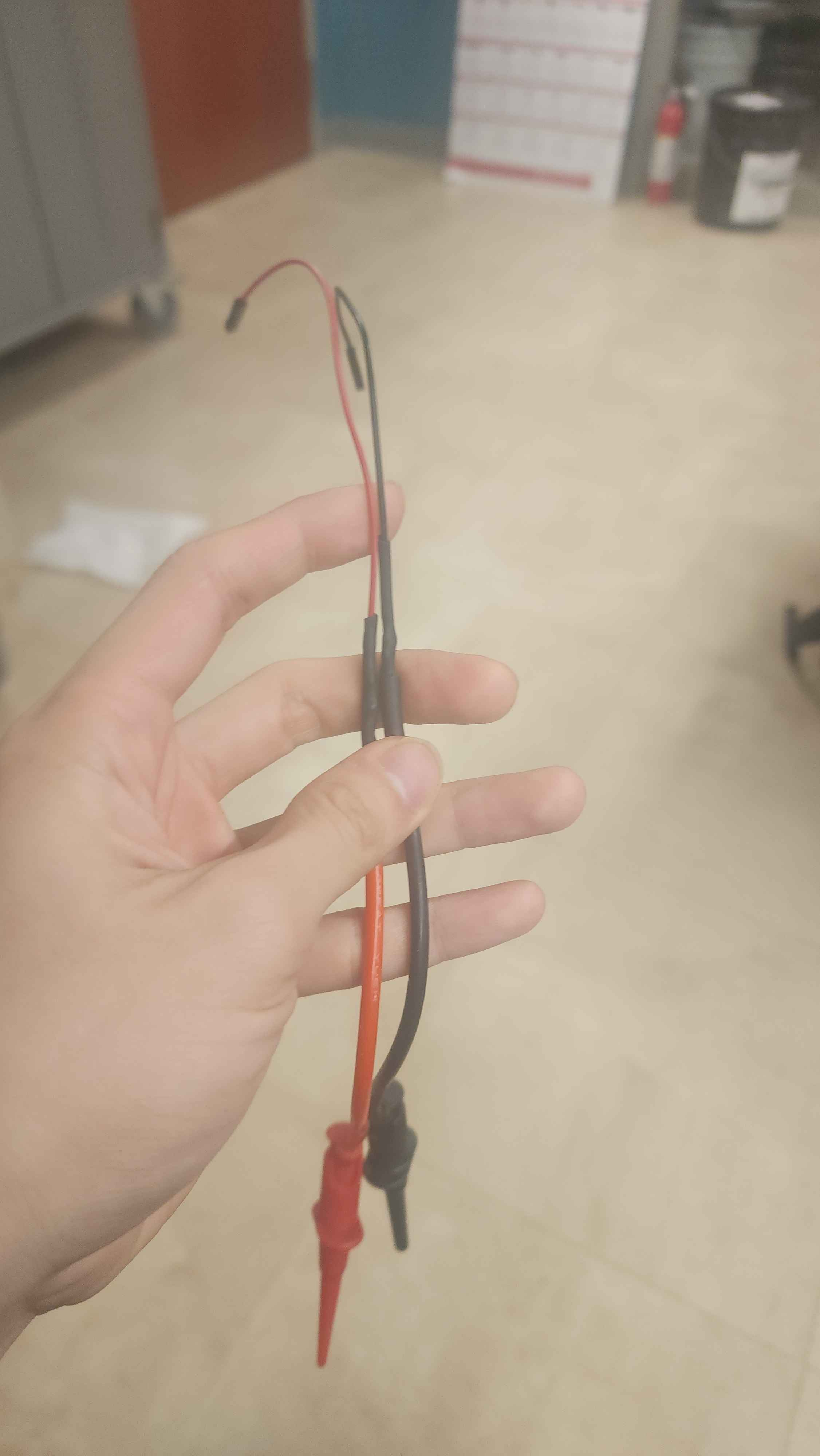 two cables, which have clamping probes on one end, and male Dupont connectors on the other side